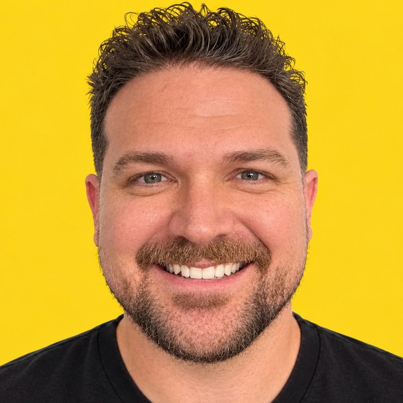 A portrait of Zach Fitzgerald smiling in a black t-shirt.